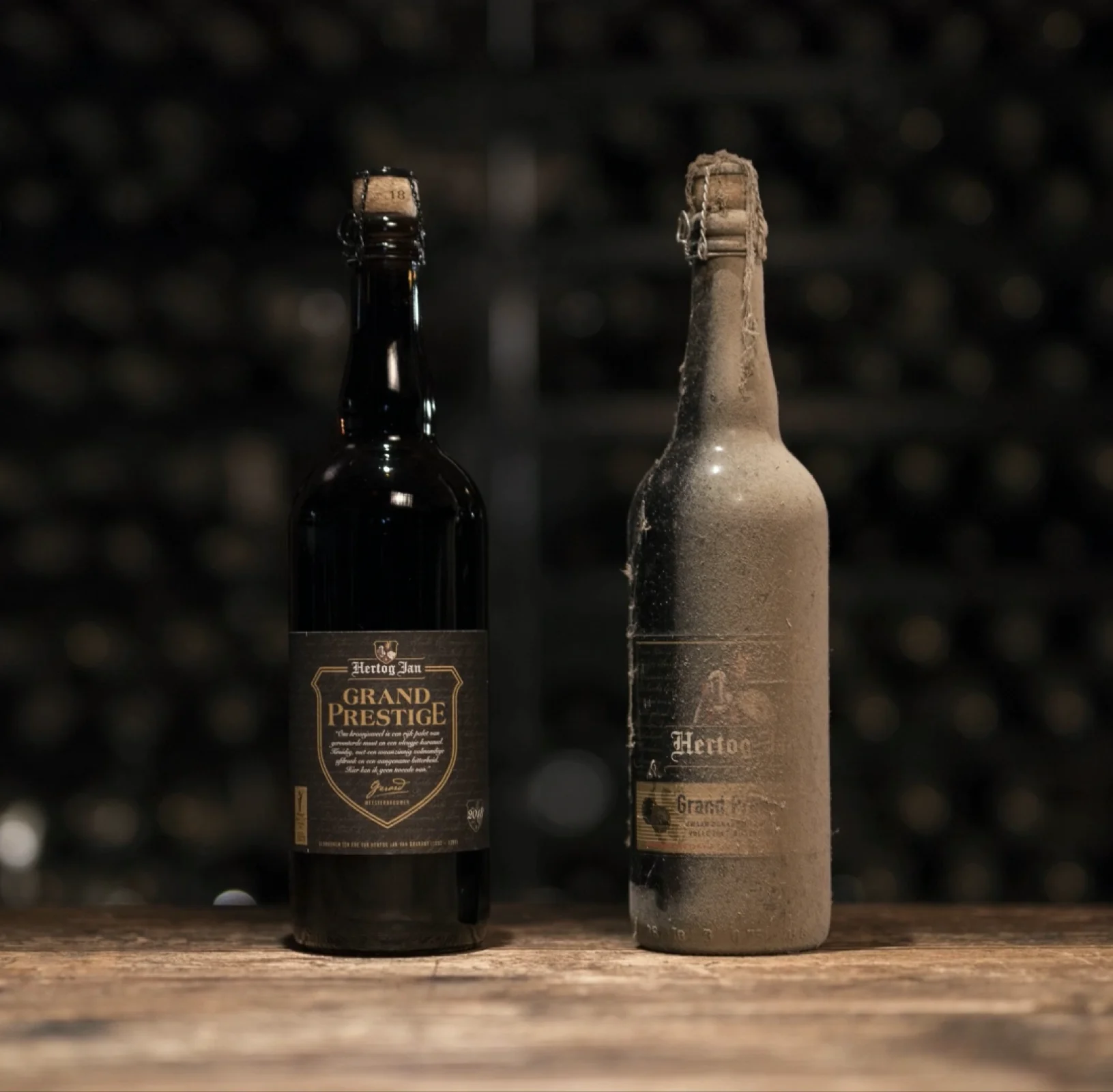 Two Grand Prestige bottles, one freshly aged, on a cellar table